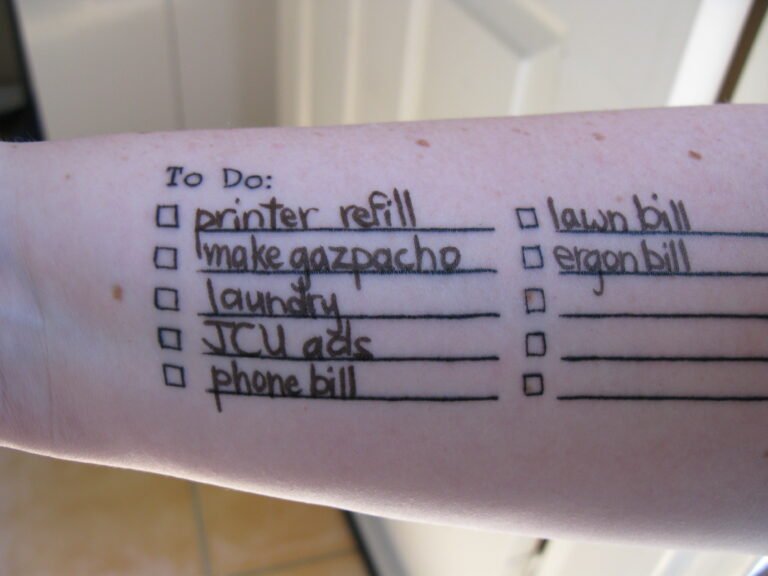 A hand writing a short to-do list in a notebook