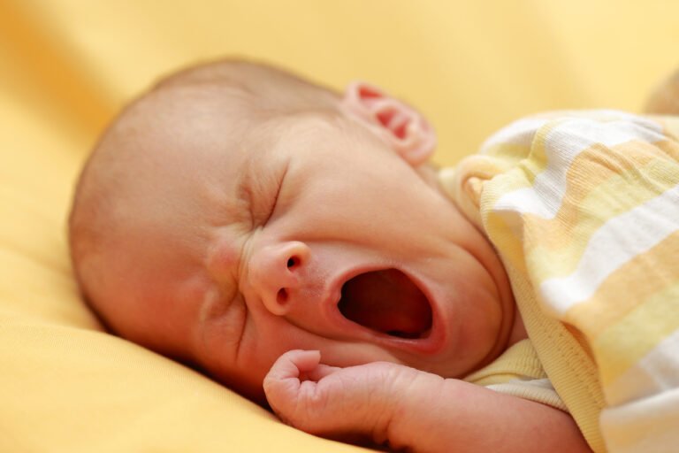A person stretching and yawning in the morning light